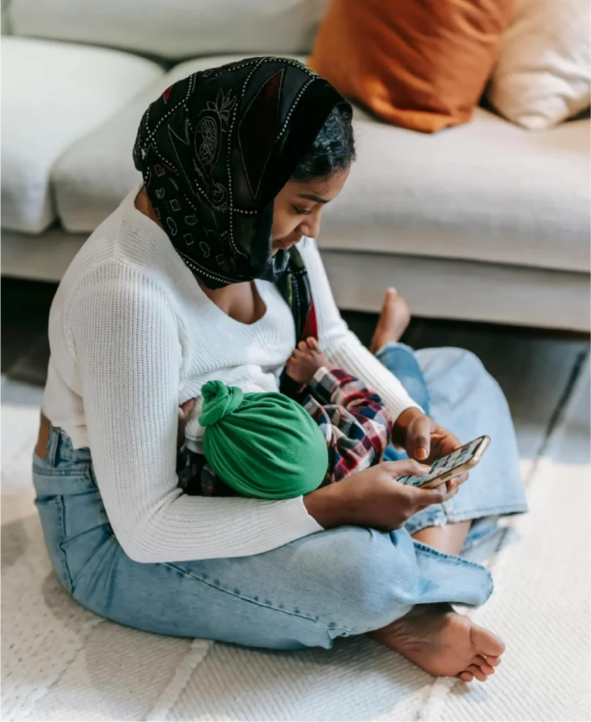 Mum breastfeeding while checking her phone